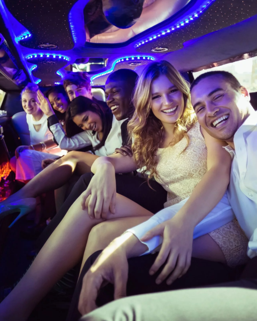A group of young adults enjoying a fun moment inside a luxurious limousine, featuring vibrant LED lighting and a lively atmosphere.